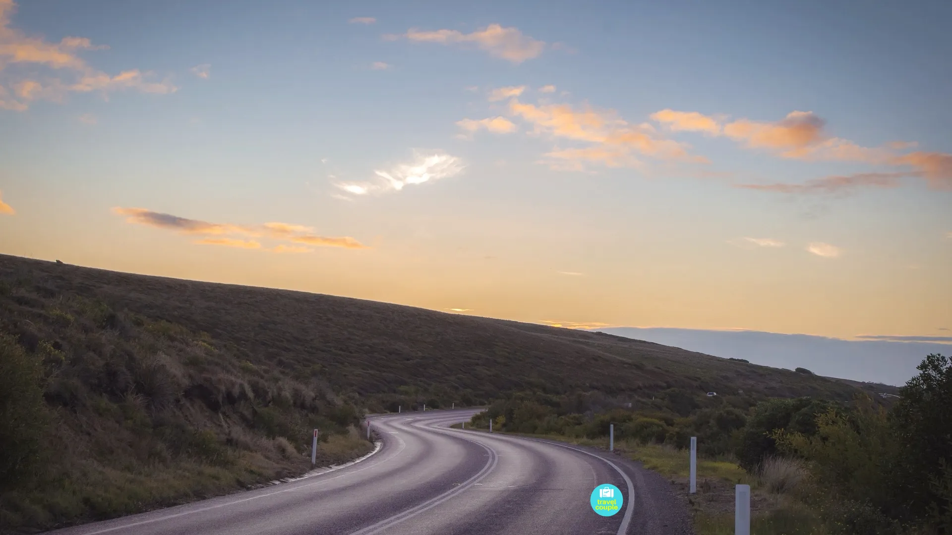 An open road beneath a warm sunset sky near the end of the Great Ocean Road journey